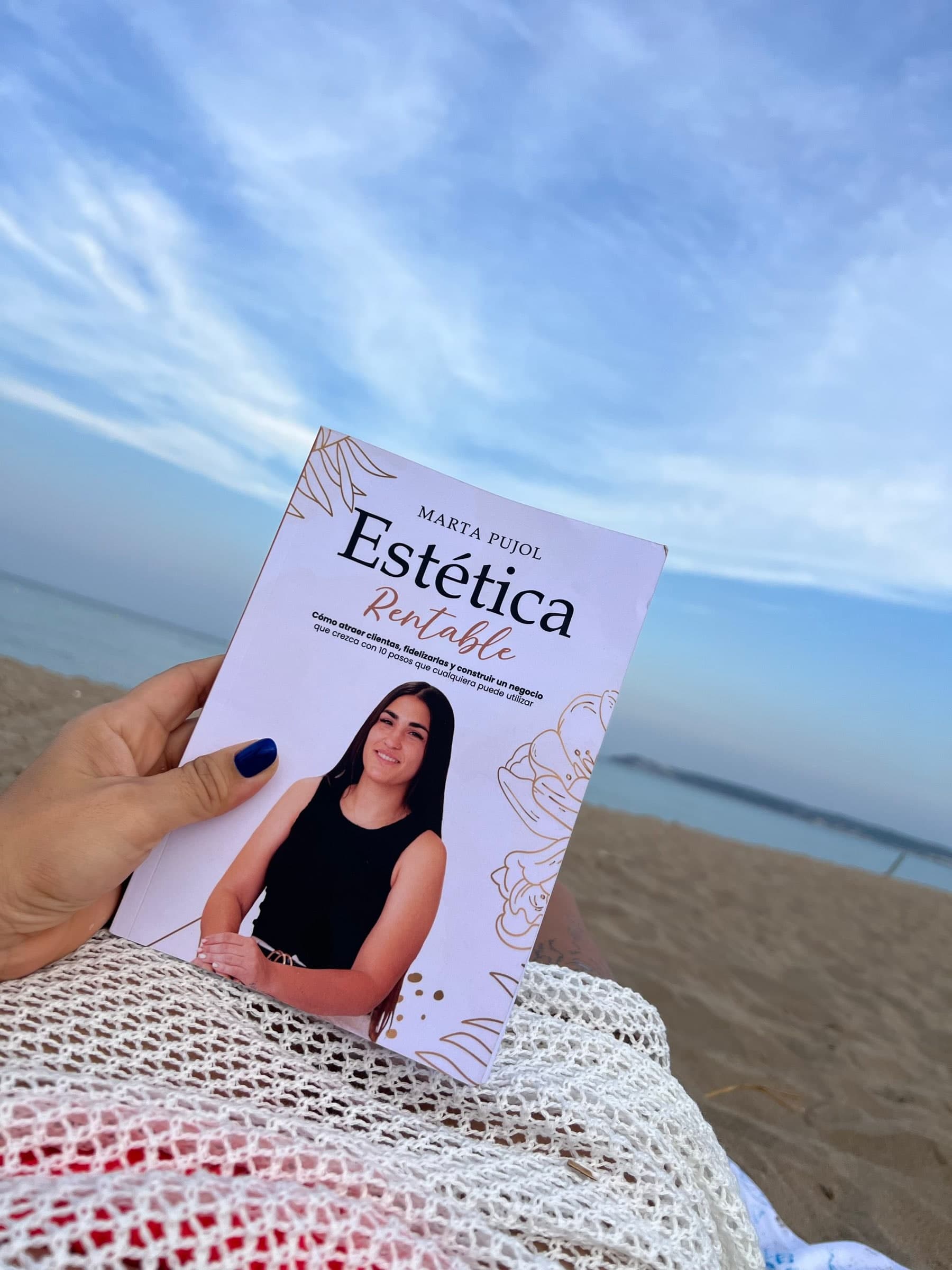 El libro Estética Rentable en la mano, frente al mar