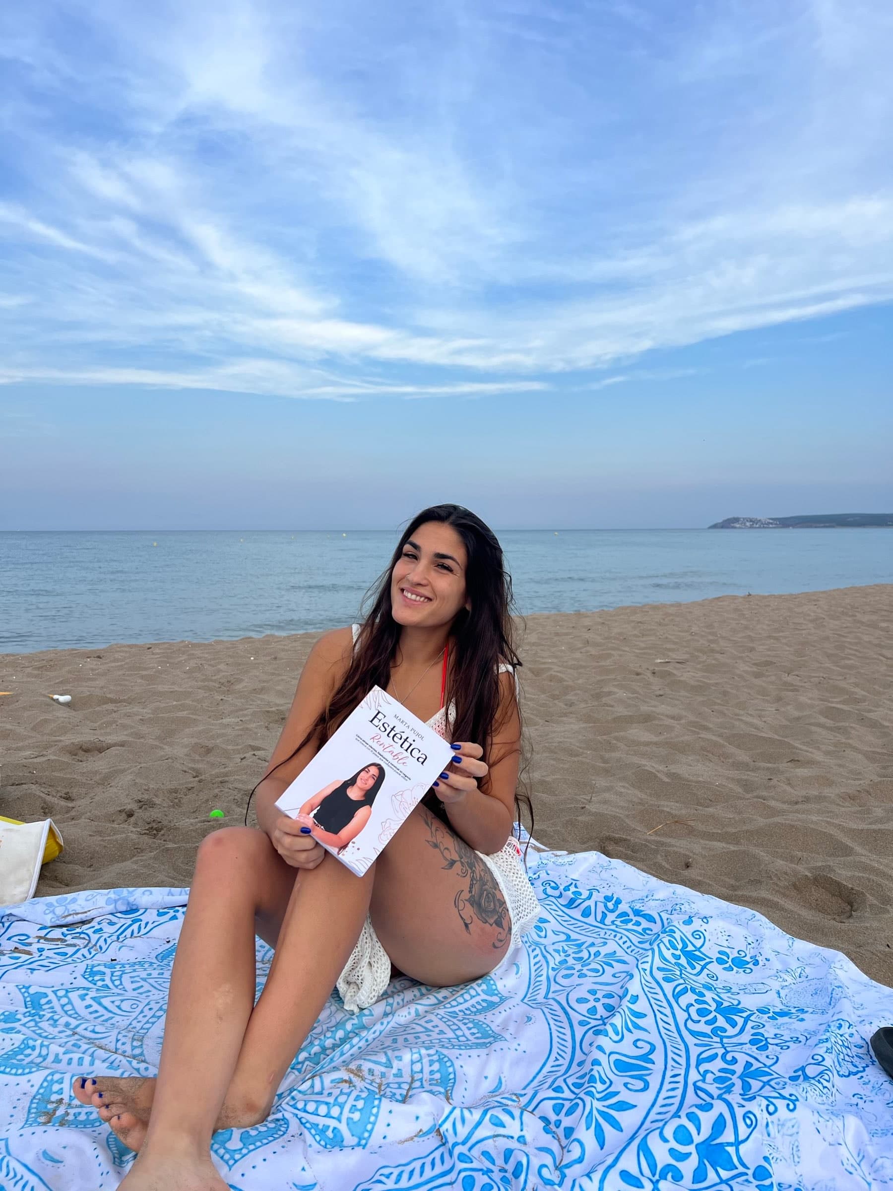 Una lectora sonriendo con el libro Estética Rentable